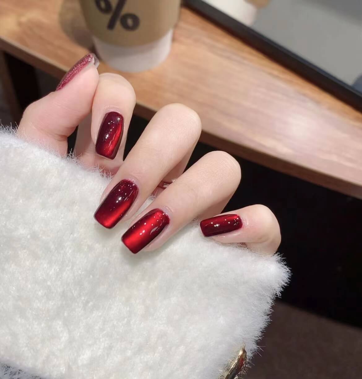 #100 Scarlet Witch magnetic cat eye gel polish featuring a powerful blend of red, maroon, and dark red tones that creates a dramatic 3D nail effect with luminous shimmer and reflective nail design, perfect for bold and seductive professional gel manicures with rich salon-quality shine and multidimensional depth.
